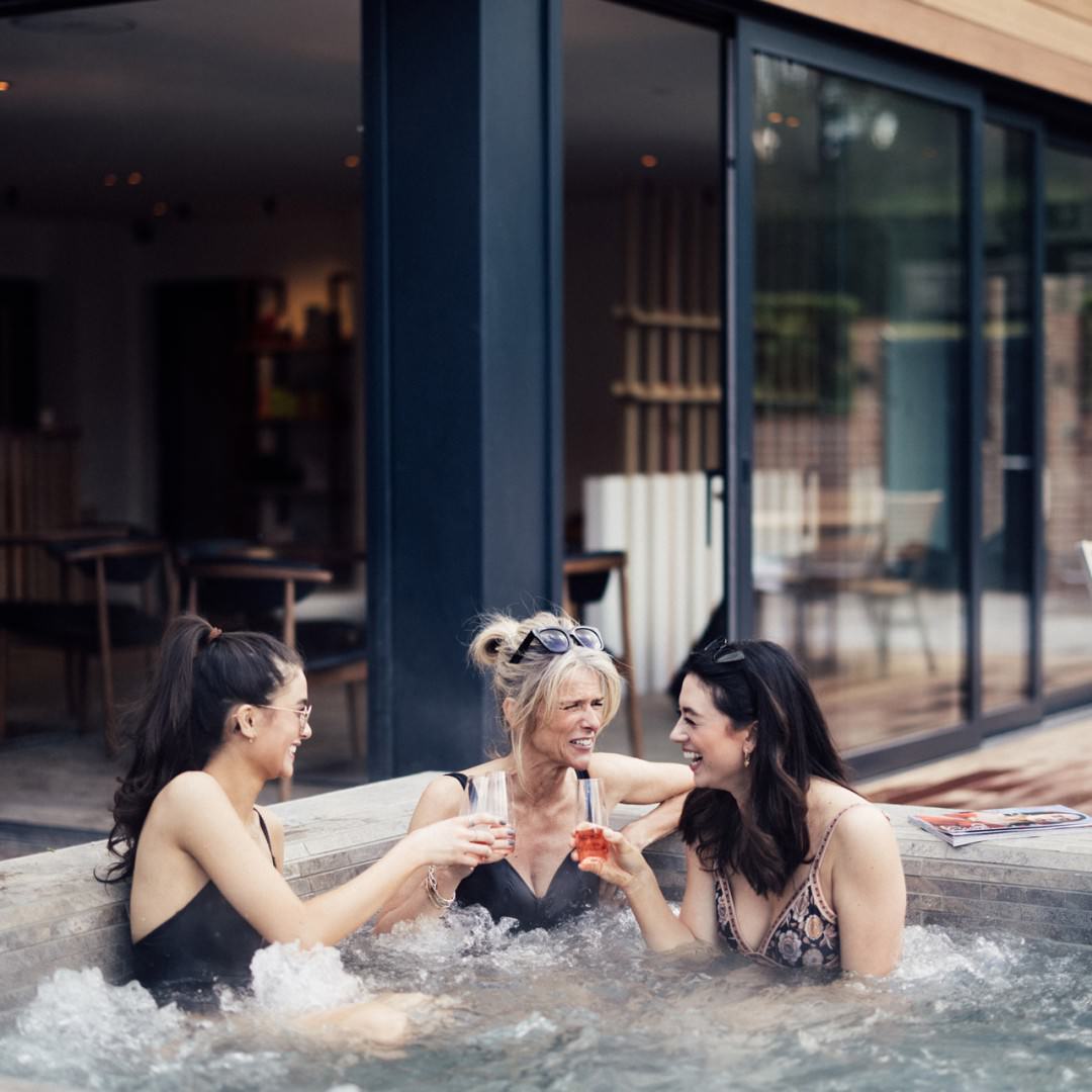 Girls doing cheers int eh hot tub at Talbooth House & Spa, Essex - one of the best spa hotels in Essex