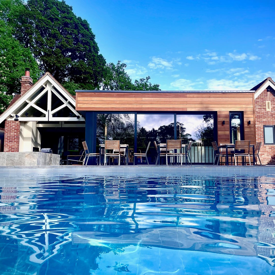 One of the best hotel spas in Essex, looking across the pool to the old poolhouse where cosy spa treatment rooms are.